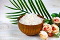 Wooden bowl with sea salt, rose and palm leaf Royalty Free Stock Photo