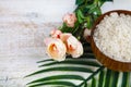 Wooden bowl with sea salt, rose and palm leaf Royalty Free Stock Photo