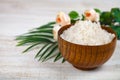 Wooden bowl with sea salt, rose and palm leaf Royalty Free Stock Photo