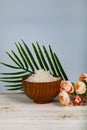Wooden bowl with sea salt, rose and palm leaf Royalty Free Stock Photo