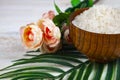 Wooden bowl with sea salt, rose and palm leaf Royalty Free Stock Photo