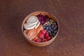 Wooden bowl with smoked salmon salad, slices of goat cheese, berries, sunflower and pumpkin seeds, lettuce and strawberry jam Royalty Free Stock Photo