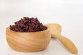 Wooden bowl and spoon with brown rice ready to eat. Deep Purple rice Royalty Free Stock Photo