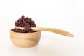 Wooden bowl and spoon with brown rice ready to eat. Deep Purple Royalty Free Stock Photo