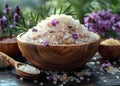 Wooden bowl and spoon filled with pink and purple bath salts and surrounded by fresh lavender flowers Royalty Free Stock Photo