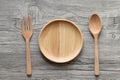 Wooden bowl with spoon and fork on wooden background