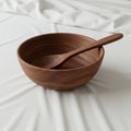 Wooden bowl and spoon on a white fabric surface. The bowl and spoon feature Royalty Free Stock Photo