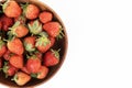 Wooden bowl of strawberries occupies the left side creating a natural frame with ample copy space Royalty Free Stock Photo