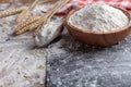 Wooden bowl of wheat flour and scoop on kitchen table. Ingredient for baking Royalty Free Stock Photo