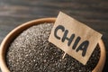 Wooden bowl and word Chia on wood background