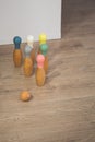 Wooden bowling toy game with a ball on a domestic indoor hardwood floor
