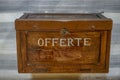 wooden box of alms or gratuities written in white letters \