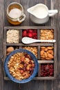 Wooden box with breakfast items - oats, granola muesli, nuts, honey, dried berries and milk. Top view.