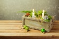 Wooden box with Christmas decorations and candles over dreamy background. Christmas table composition Royalty Free Stock Photo