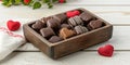 A wooden box containing various types of chocolates, including heart-shaped chocolates. Royalty Free Stock Photo