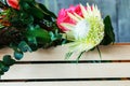 wooden box with flowers with Hydrangea purple, freesia, protea, roses