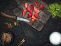 Cutting board with fresh strawberries, cup of honey, cup of milk and plate of mint leaves on vintage table. Royalty Free Stock Photo