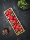 Wooden box with fresh strawberries, cup of honey and plate of mint leaves on vintage table. Royalty Free Stock Photo