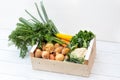Wooden box of fresh vegetables from farmers market on white painted wood table Royalty Free Stock Photo