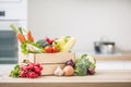 Wooden box full of fresh healthy vegetables. Broccoli carrot radish onion garlic corn on wooden kitchen table Royalty Free Stock Photo