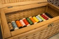 Wooden box full of thread spools multicolored