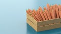 Wooden box with polygonal carrots on a blue background. The concept of selling vegetables, healthy food, seasonal