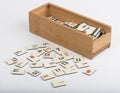 Wooden box of rummikub with pieces, white background