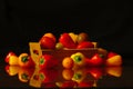 A wooden box with small peppers and a dark background, dark food