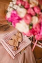 Wooden box for wedding rings with monogram of capital letters of the name in the heart on the background of the bride's