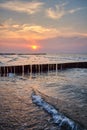 Wooden breakwater seen from a beach at sunset Royalty Free Stock Photo