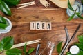 The wooden brick with words ` IDEA ` on wooden background. ECO concept with recycling symbol and leaves