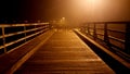 Wooden bridge access blocked with massive handrails at foggy night