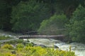 Wooden bridge across stormy mountain river