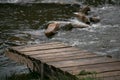 A wooden bridge on the bank of a raging river Royalty Free Stock Photo