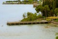 Wooden bridge within a beautiful scenery at Lake Garda in Sirmione, Italy. Royalty Free Stock Photo