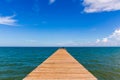 Wooden bridge extending into the sea with Deep Blue ocean sky clouds. Landscape with Ocean small waves water reflection copy space Royalty Free Stock Photo