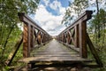 Wooden bridge in the forest with a sturdy railing. A walking area for pedestrians Royalty Free Stock Photo