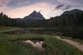 Wooden bridge at lake Antorno with reflection of the mountains of the Three Peaks during sunrise in the European Dolomite Alps Royalty Free Stock Photo