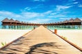 Wooden bridge leading to an exotic bungalow on the background of azure water, maldives Royalty Free Stock Photo