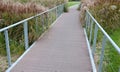 Wooden bridge with metal galvanized structure in the park. newly built for cyclists across the stream by the pond. wooden beams co
