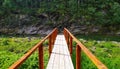 Wooden bridge in the mountain river with rocks in the background Royalty Free Stock Photo