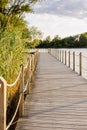 Long Wooden bridge over lake. Beautiful sunrise over lake pier. Planked footway on the river Royalty Free Stock Photo