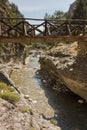 Wooden bridge over mountain river at rocky terrain of Samaria gorge, south west part of Crete island Royalty Free Stock Photo