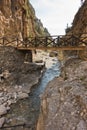 Wooden bridge over mountain river at rocky terrain of Samaria gorge, south west part of Crete island Royalty Free Stock Photo