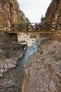 Wooden bridge over mountain river at rocky terrain of Samaria gorge, south west part of Crete island Royalty Free Stock Photo