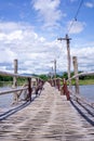 The wooden bridge over the river has a forested background. Mountains and blue skies Royalty Free Stock Photo