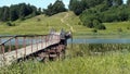 Wooden bridge over the river. Old footbridge over the reservoir. Connecting the banks of the river with a bridge. River landscape Royalty Free Stock Photo