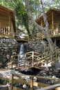 Wooden bridge over a small stream in the forest. Waterfall in the garden with rocks and leaves in autumn season. Royalty Free Stock Photo