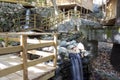 Wooden bridge over a small stream in the forest. Waterfall in the garden with rocks and leaves in autumn season. Royalty Free Stock Photo