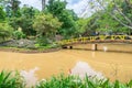 Wooden bridge over yellow river with tropical trees in the park Royalty Free Stock Photo